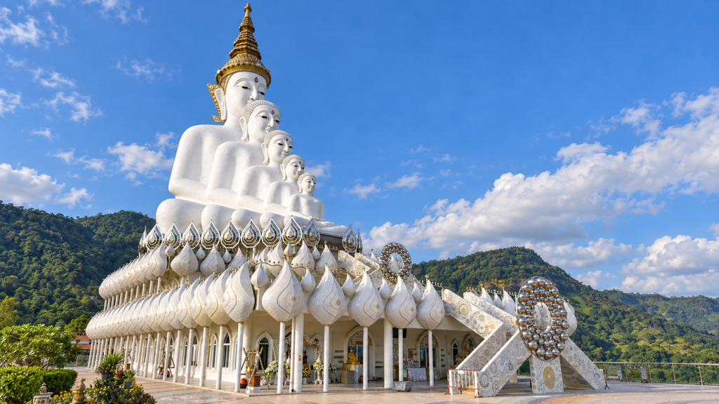 AI-genereret illustration af de fem hvide Buddhafigurer ved Wat Phra That Pha Sorn Kaew med udsmykket fælles base og grønne bakker i baggrunden.