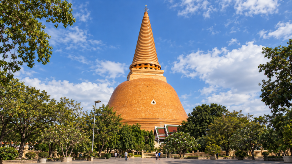 AI-genereret illustration af Phra Pathom Chedi i Nakhon Pathom med orangebrun flisebeklædning, højt spir og træer omkring tempelområdet.