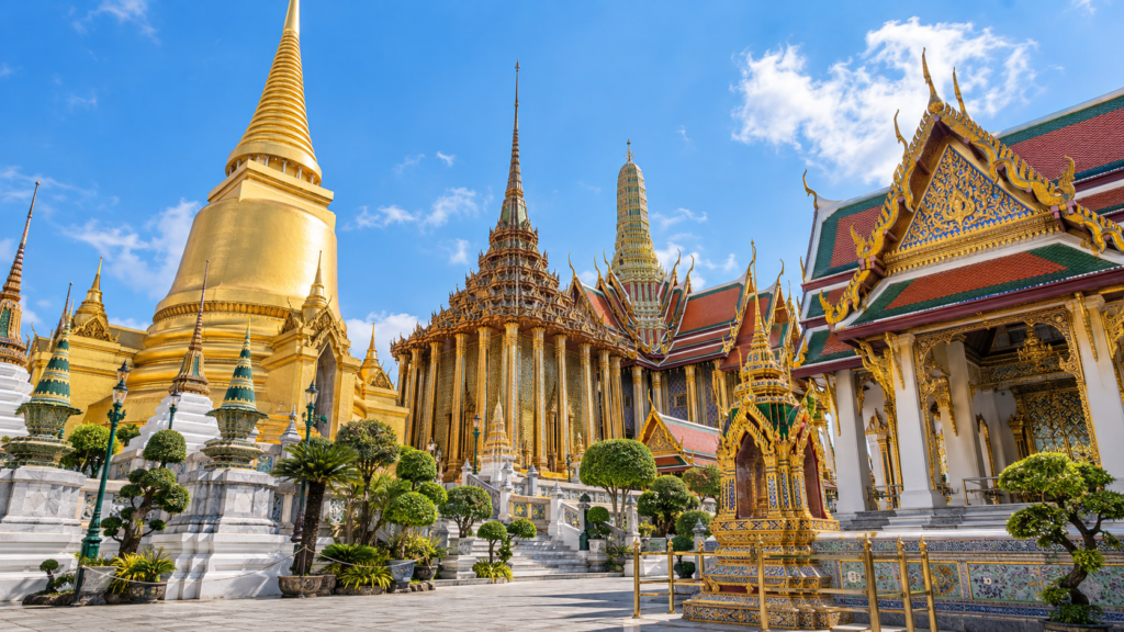 AI-genereret illustration af en gylden chedi og udsmykkede tempelbygninger inspireret af Wat Phra Kaew i Bangkok.