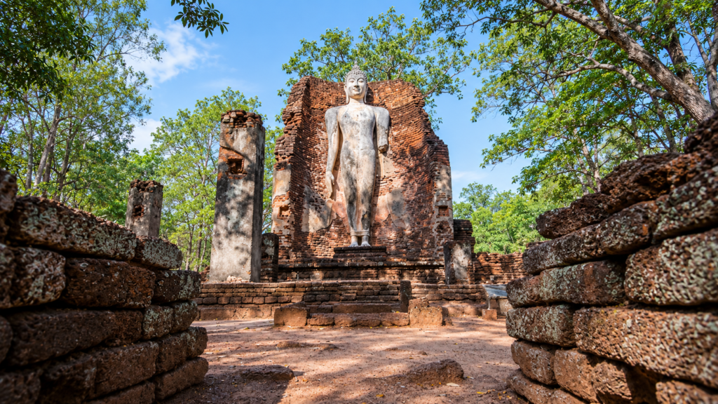 AI-genereret illustration af den stående Buddha ved Wat Phra Si Iriyabot med gamle tempelmure og grønne træer.
